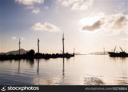 renewable energy, technology and power concept - turbines at wind farm on sea shore. turbines at wind farm on sea shore
