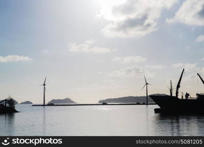 renewable energy, technology and power concept - turbines at wind farm on sea shore. turbines at wind farm on sea shore