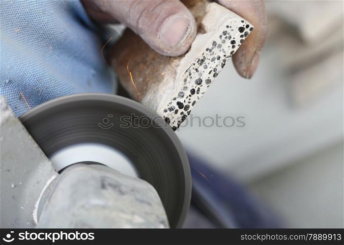 Renovation at home worker cuts tile with angle grinder electric tool man is tiling at home construction site