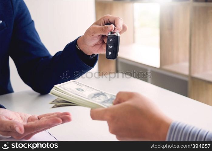 Rental agreement for signing a car insurance policy Document and Form of a Vehicle Sales Agreement, the agent is holding the document and car key