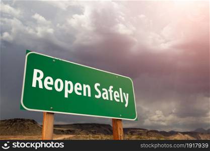Reopen Safely Green Road Sign Against Ominous Stormy Cloudy Sky.