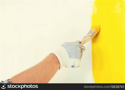repair, building and home concept - close up of male in gloves holding paintbrush