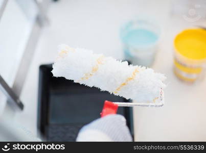 repair, building and home concept - close up of male in gloves holding painting roller