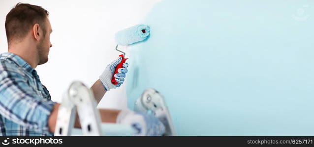 repair, building and home concept - close up of male in gloves holding painting roller