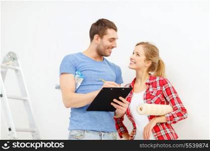repair, building and home concept - smiling couple with clipboard, wallpaper roll and ladder
