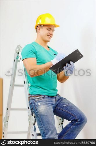 repair, building and home concept - smiling man in protective helmet with clipboard