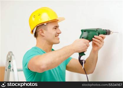 repair, building and home concept - smiling man in yellow protective helmet with electric drill making hole in wall
