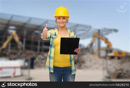 repair, building, construction and maintenance concept - smiling woman in helmet with clipboard showing thumbs up