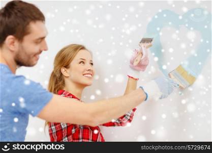 repair, building, love, people and home concept - smiling couple painting small heart on wall at home