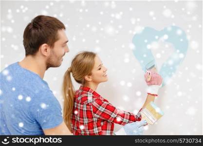 repair, building, love, people and home concept - smiling couple painting small heart on wall at home