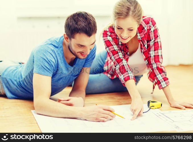 repair, building, renovation and home concept - smiling couple looking at blueprint at home