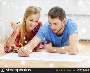 repair, building, renovation and people concept - smiling couple looking at blueprint at home