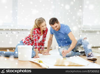 repair, building, teamwork and home concept - smiling couple smearing wallpaper with glue