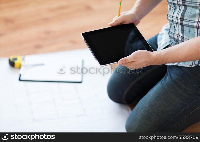 repair, building, technology and home concept - close up of male with tablet pc, blueprint and measuring tape