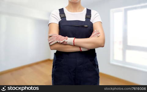 repair, construction and building concept - close up of female painter or builder in overall over empty room at new home background. close up of female painter or builder in overall