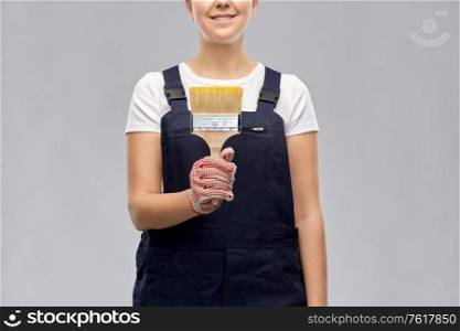 repair, construction and building concept - close up of happy smiling female painter or builder with paint brush over grey background. close up of painter or builder with paint brush