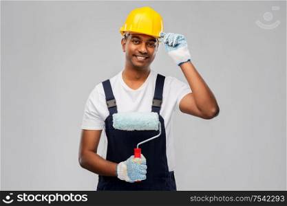 repair, construction and building - happy smiling indian builder or painter in helmet with paint roller over grey background. happy indian painter or builder with paint roller