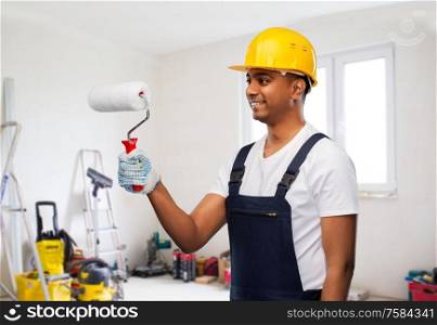 repair, construction and building - happy smiling indian builder or painter in helmet with paint roller over room with working equipment at new home or apartment background. happy indian painter or builder with paint roller