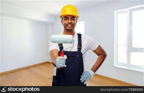 repair, construction and building - happy smiling indian builder or painter in helmet with paint roller over empty home or apartment room background. happy indian painter or builder with paint roller