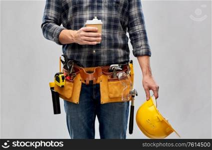 repair, construction and building - male worker or builder with coffee cup, helmet and working tools on belt over grey background. male builder with coffee, helmet and working tools