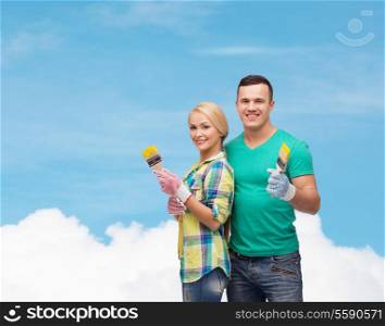 repair, construction and maintenance concept - smiling couple with paintbrush