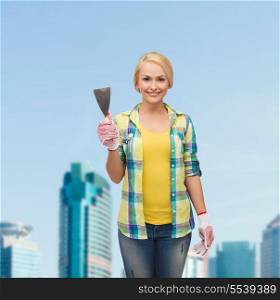 repair, construction and maintenance concept - smiling female worker in gloves with spatula