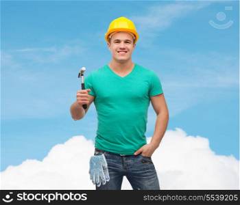 repair, construction and maintenance concept - smiling male manual worker in protective helmet with hammer