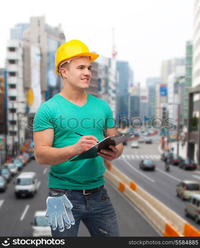 repair, construction and maintenance concept - smiling man in helmet with clipboard