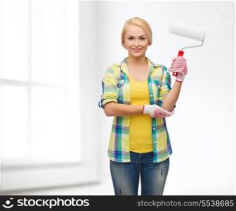 repair, construction and maintenance concept - smiling woman in gloves with paint roller