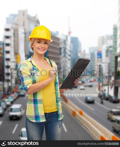 repair, construction and maintenance concept - smiling woman in helmet with clipboard