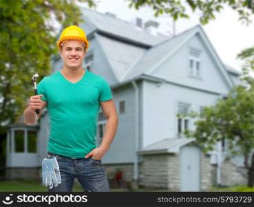 repair, construction, people, building and maintenance concept - smiling male manual worker in protective helmet holding hammer over house background