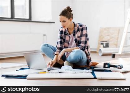 repair, improvement and furniture concept - woman with laptop assembling new locker at home. woman with laptop assembling new furniture at home