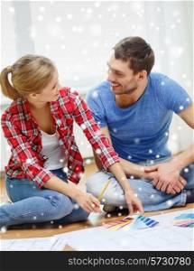 repair, interior design, building, renovation and people concept - smiling couple selecting color from samples at home