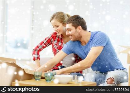 repair, moving in and people concept - smiling couple opening , unpacking cardboard box with dishes at home