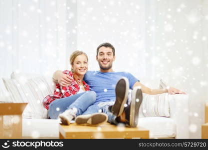 repair, moving in and people concept - smiling couple relaxing and hugging on sofa in new home