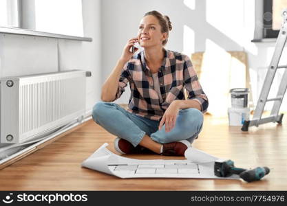 repair, people and real estate concept - happy smiling woman with blueprint and pencil sitting on floor at home and calling on smartphone. woman with blueprint calling on smartphone at home