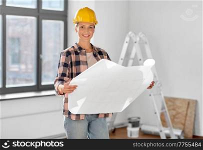 repair, people and real estate concept - woman in helmet with blueprint sitting on floor at home. woman in helmet with blueprint at home