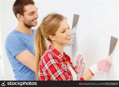 repair, renovation and home concept - smiling couple doing renovations at home