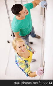 repair, renovation and home concept - smiling couple doing renovations at home