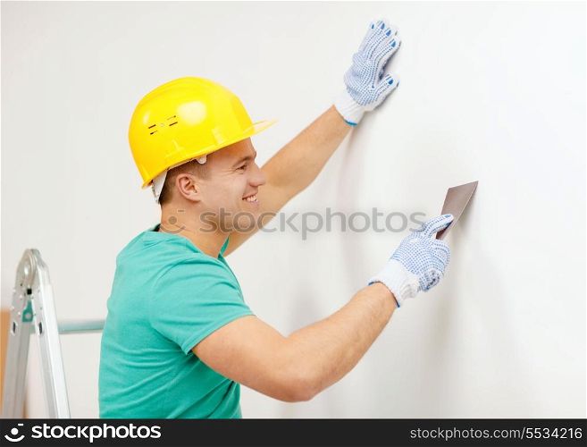 repair, renovation and home concept - smiling man in helmet doing renovations at home