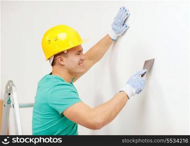 repair, renovation and home concept - smiling man in helmet doing renovations at home