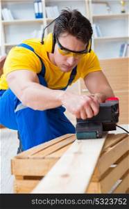 Repairman carpenter polishing a wooden board with an electric po. Repairman carpenter polishing a wooden board with an electric power polisher grinding wheel