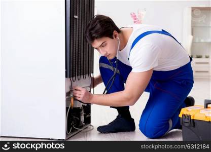 Repairman contractor repairing fridge in DIY concept. The repairman contractor repairing fridge in diy concept