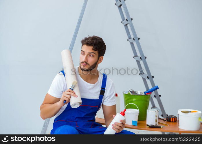 Repairman doing renovation repair in the house with paper wallpa. Repairman doing renovation repair in the house with paper wallpaper