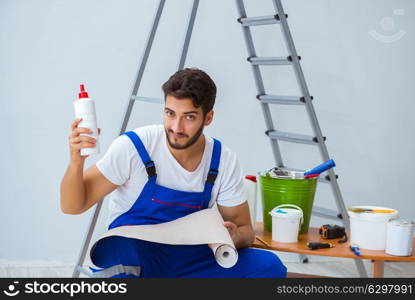 Repairman doing renovation repair in the house with paper wallpa. Repairman doing renovation repair in the house with paper wallpaper