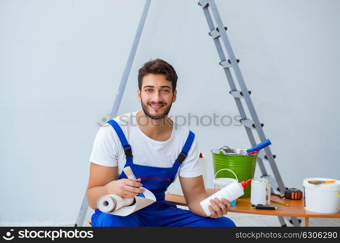 Repairman doing renovation repair in the house with paper wallpa. Repairman doing renovation repair in the house with paper wallpaper