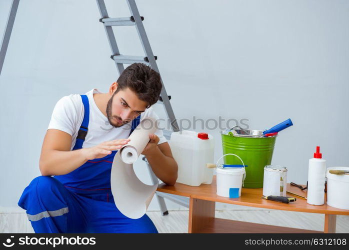 Repairman doing renovation repair in the house with paper wallpa. Repairman doing renovation repair in the house with paper wallpaper