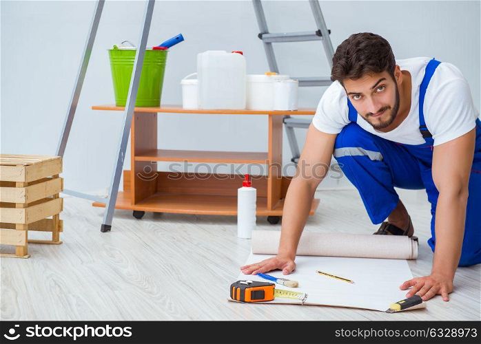 Repairman doing renovation repair in the house with paper wallpa. Repairman doing renovation repair in the house with paper wallpaper