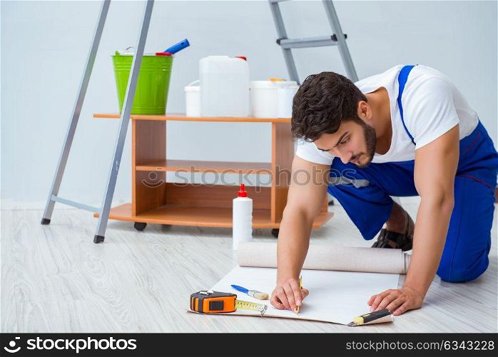 Repairman doing renovation repair in the house with paper wallpa. Repairman doing renovation repair in the house with paper wallpaper