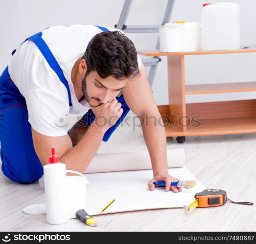 Repairman doing renovation repair in the house with paper wallpaper. Repairman doing renovation repair in the house with paper wallpa